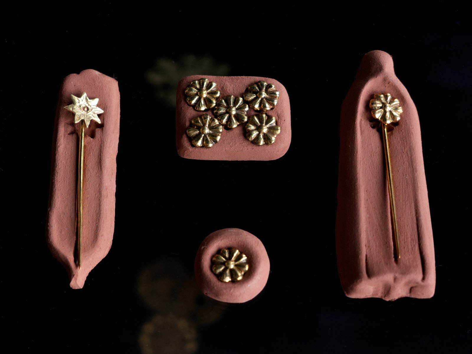 buttons and tie pins on terracotta setting